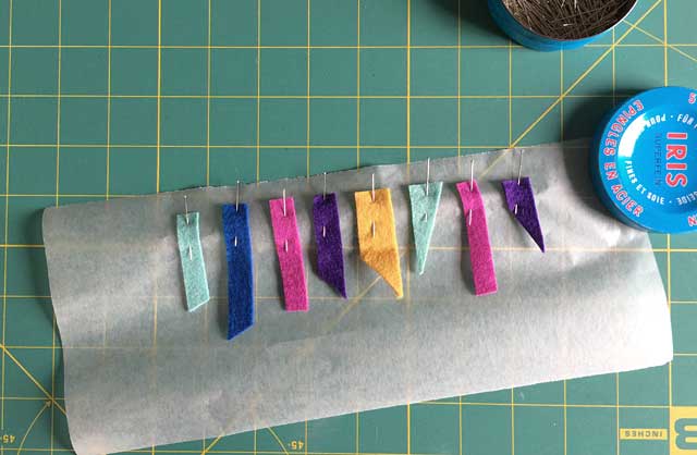 How to make felt garland sewing the shapes on tissue paper