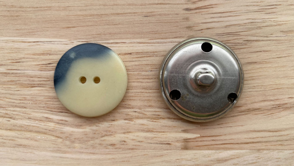 2 buttons. One with holes and one with a shank
